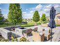 Outdoor patio with a firepit, stylish seating, and views of the landscaped backyard and pond at 6064 Bartley Dr, Noblesville, IN 46062
