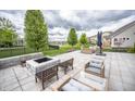 Spacious backyard patio with a stone firepit, comfortable seating, and a view of the pond at 6064 Bartley Dr, Noblesville, IN 46062