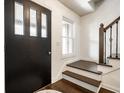 Bright foyer with hardwood floors, stairs, and a black front door with glass panes at 6938 Rio Grande Dr, Indianapolis, IN 46217