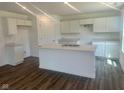 A modern kitchen featuring a kitchen island with sink, bright white cabinets, and wood floors at 7509 Big Bend Blvd, Camby, IN 46113