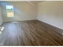 A naturally lit empty living room featuring wood floors and white walls with a clear window view at 7509 Big Bend Blvd, Camby, IN 46113