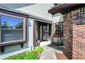 Inviting entrance showcasing a brick accent wall, cozy bench, and well-manicured greenery, offering curb appeal at 7702 Justin Ln, Indianapolis, IN 46219
