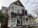 Exterior of a distressed two-story home with peeling paint and aged wood siding at 802 S Anderson St, Elwood, IN 46036
