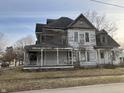 Two story home with covered porch and peeling paint in need of renovation at 802 S Anderson St, Elwood, IN 46036