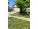 Single Gathering home with large green tree in yard and long driveway on a sunny day at 8054 Painted Pony Dr, Indianapolis, IN 46217