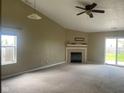 Bright and airy living room featuring a fireplace, ceiling fan, and sliding glass doors to the backyard at 8054 Painted Pony Dr, Indianapolis, IN 46217