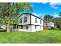 Charming two-story home with well-maintained lawn, bright white siding, black trim, and mature shade tree at 8103 Laughlin Dr, Indianapolis, IN 46219