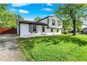 Charming two-story home with freshly cut lawn, bright white siding, black trim, and lovely curb appeal at 8103 Laughlin Dr, Indianapolis, IN 46219