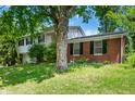 A view of the exterior of the two-story home on a green, grassy lawn with a large tree providing shade at 8227 Hoover Ln, Indianapolis, IN 46260