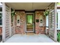 Charming covered entryway showcasing brick pillars, decorative sconces, and a welcoming front door at 8834 W 1050 S, Fortville, IN 46040