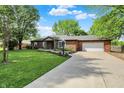 Lovely red brick ranch-style home featuring mature trees, green lawn and extended driveway at 8834 W 1050 S, Fortville, IN 46040