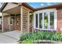 Inviting front porch with lattice details, brick accents and lush landscaping around the bay window at 8834 W 1050 S, Fortville, IN 46040