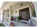Charming front porch featuring a cozy bench and decorative plants, leading to the welcoming front door at 905 N Main St, Fortville, IN 46040