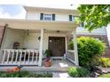 Inviting front porch with seating, decorative plants, and a charming entrance to this lovely home at 905 N Main St, Fortville, IN 46040