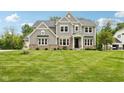 Charming two-story home with a lush green lawn and attractive landscaping in a desirable neighborhood at 9155 Kerwood Dr, Indianapolis, IN 46240
