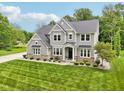 Well-maintained two-story home with stone accents, green lawn, and a well-manicured yard at 9155 Kerwood Dr, Indianapolis, IN 46240