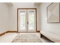 Bright foyer featuring tiled floors, white french doors, and modern artwork creating an elegant entrance at 9387 Sullivan Pl, Zionsville, IN 46077
