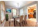 Cozy dining room with glass-top table, seating for six, and view to the kitchen and door to yard at 980 Red Maple Ct, Greenwood, IN 46143