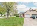 Landscaped front yard of a single-Gathering home with an attached garage and a concrete driveway at 980 Red Maple Ct, Greenwood, IN 46143