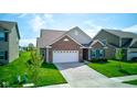 Inviting brick house with a two-car garage and lush green lawn on a sunny day at 9823 Pica Dr, Fishers, IN 46040
