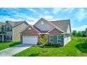 Beautiful home with green lawn, brick facade, green shutters, and a two-car garage at 9823 Pica Dr, Fishers, IN 46040