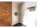 A front door on a brick wall with a gold framed picture and wall sconce at 1142 Canterbury S Sq # B, Indianapolis, IN 46260