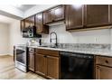 This kitchen has wood cabinets, stainless steel appliances, light counters, and a black dishwasher at 1142 Canterbury S Sq # B, Indianapolis, IN 46260