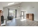 Bright living room with fireplace, vaulted ceiling with skylight, and light gray walls and flooring at 11614 Buttonwood Dr, Carmel, IN 46033