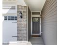 Close-up of the front door with stone accents and modern lighting fixtures at 1289 Sunset Blvd, Avon, IN 46123