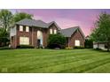 Elegant brick home with arched window and landscaped lawn, bathed in soft twilight at 13248 Blacktern Way, Carmel, IN 46033