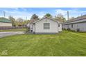 This cozy home features a well-maintained lawn and white siding, offering comfortable outdoor space at 1391 N Shadeland Ave, Indianapolis, IN 46219