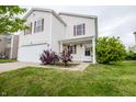 Two-story home features a two-car garage, a front lawn, and landscaping at 1404 Norton Dr, Greenwood, IN 46143