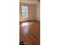 A bright bedroom featuring new, light-colored laminate wood flooring and a window at 1632 W 8Th W St, Anderson, IN 46016