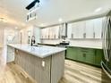 Open kitchen with an island, stainless steel appliances, and white and green cabinets at 1721 Thaddeus St, Indianapolis, IN 46203