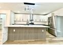 Modern kitchen featuring a waterfall island, stainless steel appliances, and stylish pendant lighting at 1721 Thaddeus St, Indianapolis, IN 46203