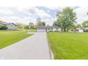 Charming single-story home featuring a two car garage and a well manicured lawn at 2237 W 100 N, Greenfield, IN 46140