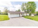 Charming single-story home featuring a two car garage and a well manicured lawn at 2237 W 100 N, Greenfield, IN 46140