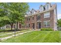 Brick townhome featuring manicured lawn, sidewalks, and tree lined streets at 2405 N Park Ave, Indianapolis, IN 46205