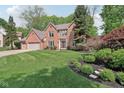 Beautiful brick home features a lush green lawn, manicured landscaping, and an attached two car garage at 2884 Brook Vista Dr, Carmel, IN 46032