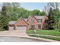 Elegant two story red brick home with a three car garage and a well maintained lawn and landscaping at 2884 Brook Vista Dr, Carmel, IN 46032