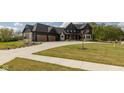 Well-manicured lawn and dark exterior of this two-story home with a three car garage and elegant landscaping at 4078 Besbie Way, Bargersville, IN 46106