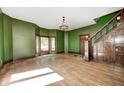 An empty living room showcasing refinished hardwood floors, fresh paint and original staircase at 4302 Kessler Blvd N Dr, Indianapolis, IN 46220