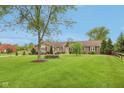 Single story ranch home with mature landscaping, stone accents, vinyl siding, lush lawn and a long driveway at 4732 Ferguson Rd, Indianapolis, IN 46239