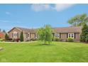 Ranch style home with professional landscaping, mature trees, plush lawn, and updated vinyl siding and roofing at 4732 Ferguson Rd, Indianapolis, IN 46239