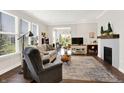 Light filled living room featuring hardwood floors, a cozy fireplace, and comfortable seating at 4965 Eldon Dr, Noblesville, IN 46062