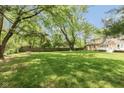 Expansive backyard featuring a well-maintained lawn, mature trees, and a privacy fence, ideal for outdoor activities at 5015 E 70Th E St, Indianapolis, IN 46220