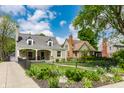 Attractive exterior view of home with stone facade, nice landscaping, and black fence at 5224 Boulevard Pl, Indianapolis, IN 46208