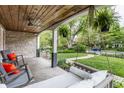 Cozy covered front porch with swing, chairs, and lovely views of the yard at 5224 Boulevard Pl, Indianapolis, IN 46208