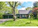 Inviting home exterior showcasing the attached garage, lush lawn, and established landscaping at 5721 Daphne Dr, Indianapolis, IN 46278