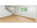 Bright living room featuring new laminate floors, fresh gray paint, a staircase, and an abundance of natural light at 5721 Daphne Dr, Indianapolis, IN 46278